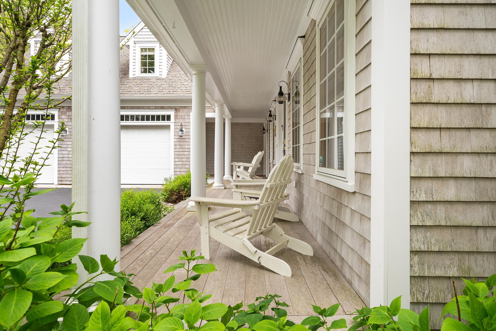 A welcoming covered front porch with Adirondack chairs